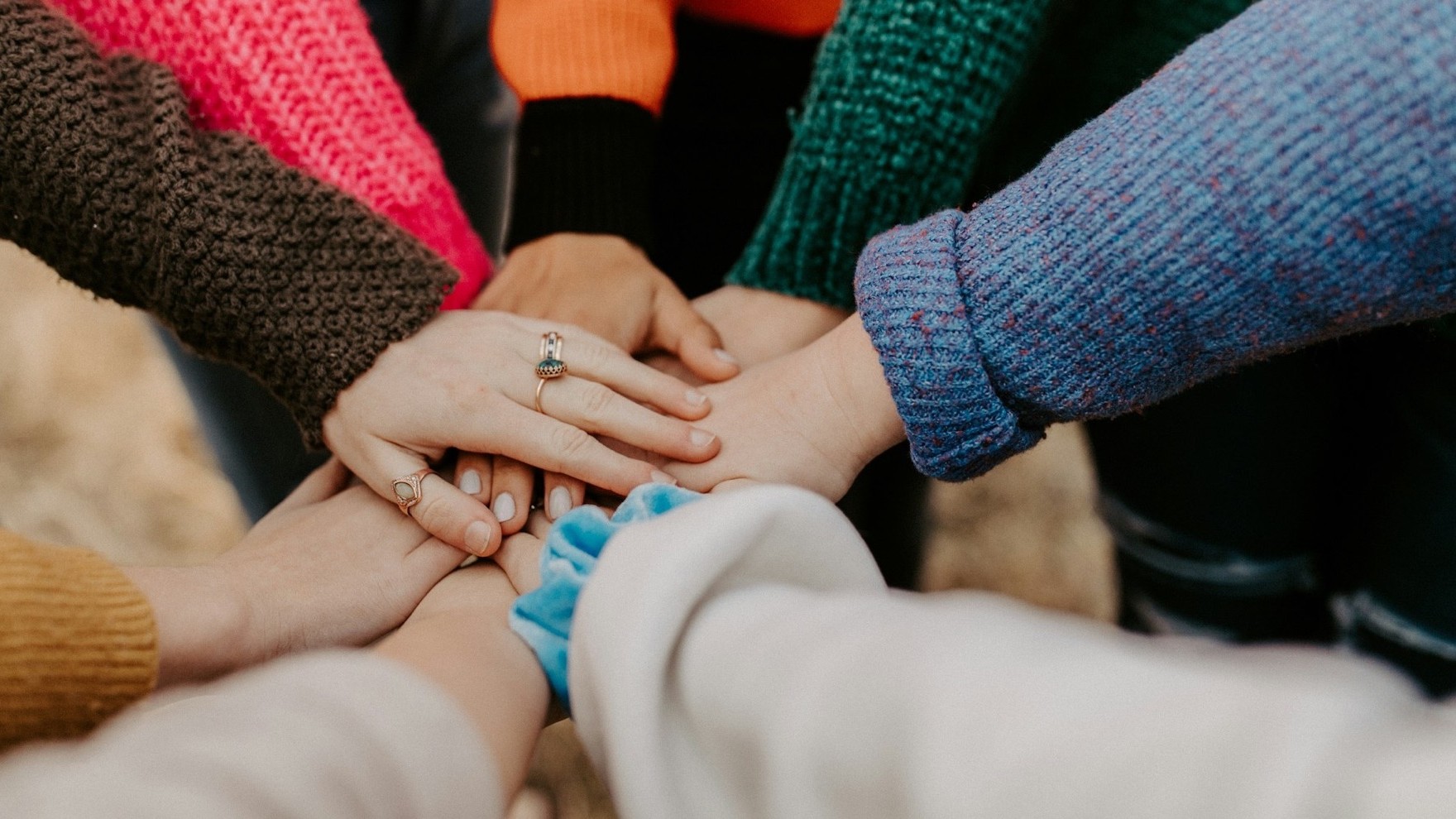Hände verschiedener Menschen liegen übereinander – gemeinsames Engagement